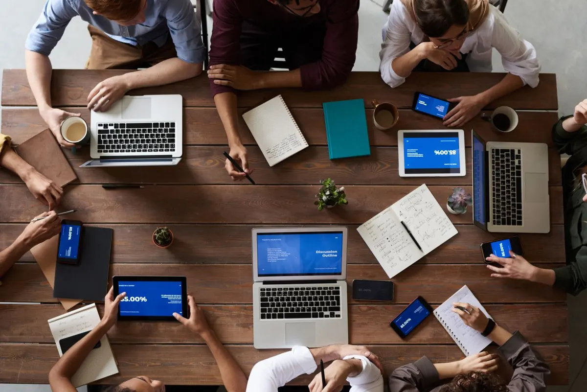 Team planning around a table with laptops and notes, seen from above